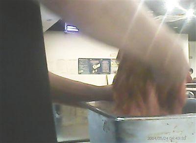 在開(kāi)餐前，烤肉店一名員工正徒手?jǐn)嚢枞馄?
